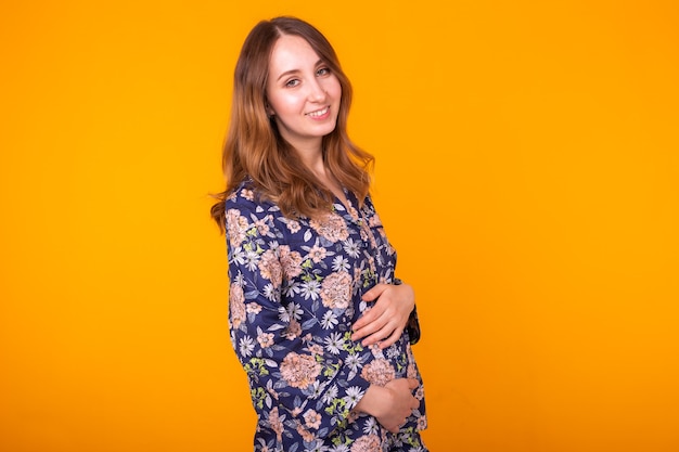 Cheerful woman in home wear pajama on yellow