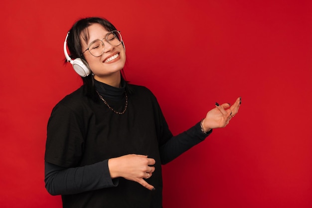 Cheerful woman is having fun while she is listening to the music in headphones