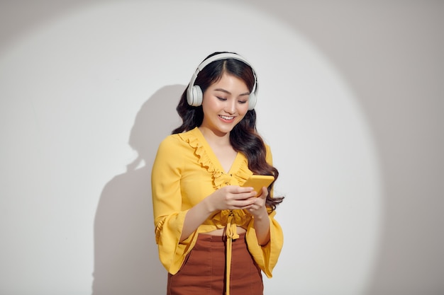 Cheerful woman listening to music with headphones isolated