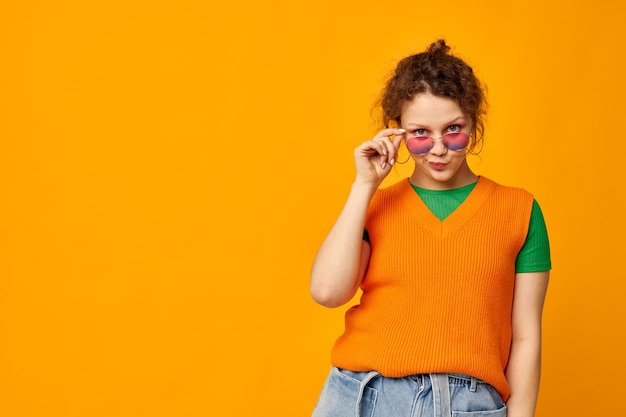 Cheerful woman orange sweatshirts sunglasses multicolored glasses supply cropped view unaltered