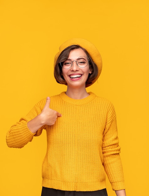 Cheerful woman pointing at chest in approval