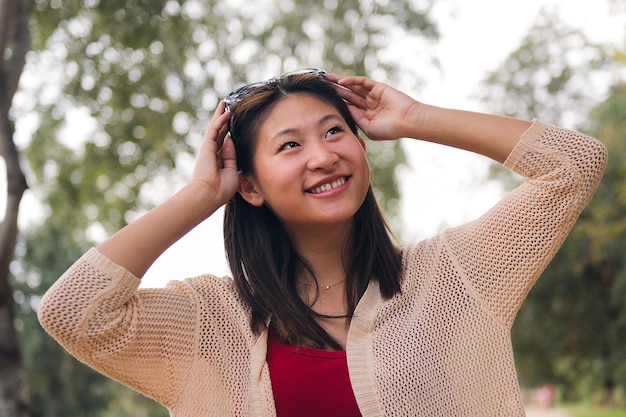 Cheerful woman putting on sunglasses on her head