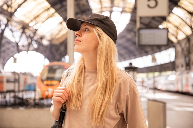 Cheerful woman at railway station look away