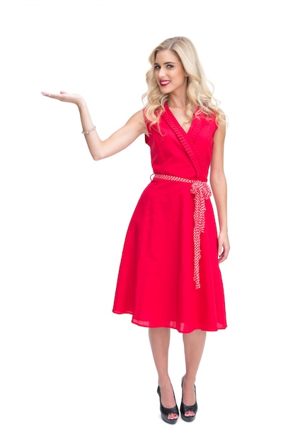 彼女の手に何かを提示している赤いドレスの明るい女性