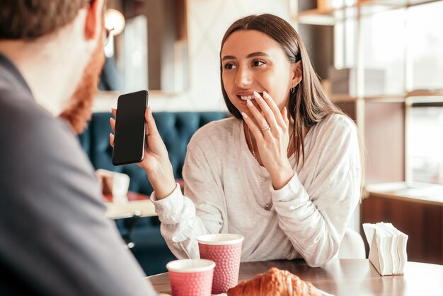 彼氏にソーシャル メディアを示す陽気な女性