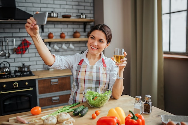 Cheerful woman sit at table in kitchen