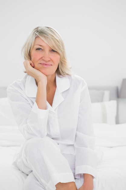 Cheerful woman sitting in her bedroom