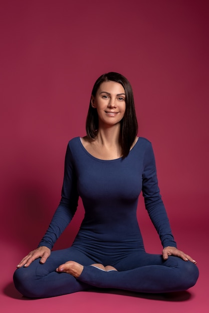 Photo cheerful woman sitting in lotus position