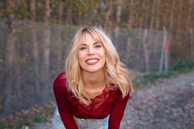 Cheerful woman smiling at camera in autumn forest