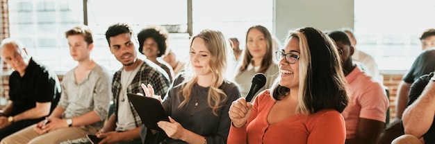 Cheerful woman speaking on a microphone in a workshop