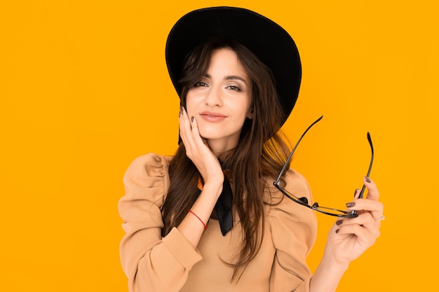 Cheerful woman with long hair smiles on white wall