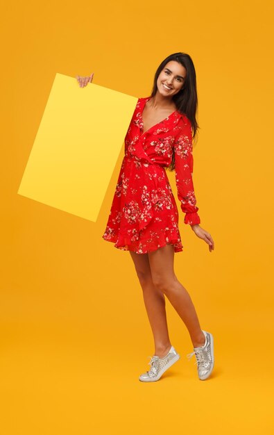 Cheerful woman with yellow poster