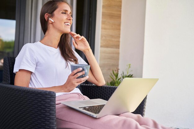 Cheerful woman working online outdoors