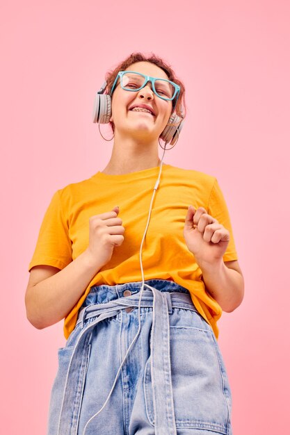 Cheerful woman yellow tshirt headphones entertainment music fun cropped view unaltered