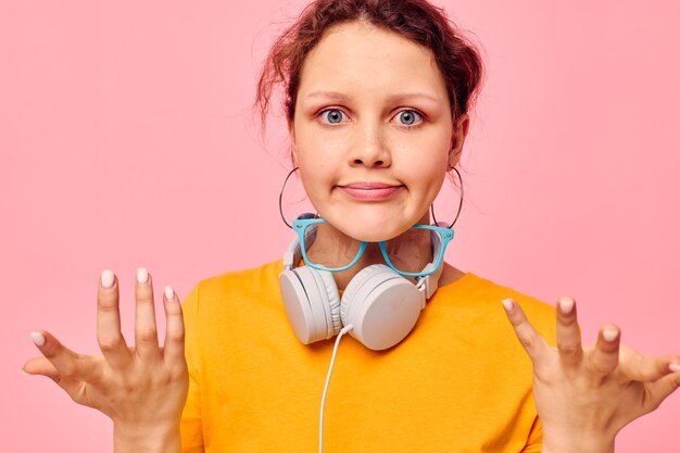 Cheerful woman yellow tshirt headphones entertainment music fun isolated backgrounds unaltered