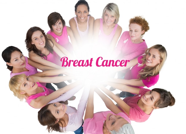 Photo cheerful women joined in a circle and looking up at camerawearing pink for breast cancer