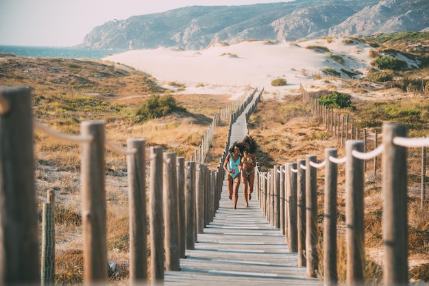 Cheerful women running on pier