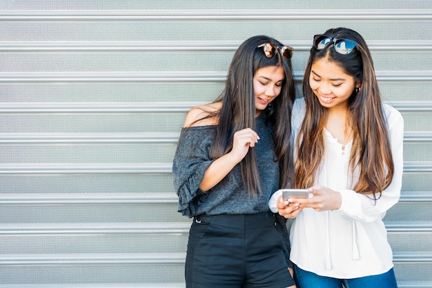 Cheerful women with smartphone in city