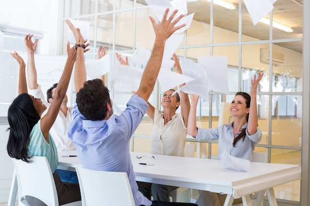 Photo cheerful workers throwing paper and smiling