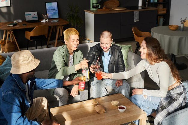 Cheerful young adults toasting at home