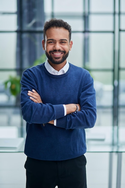 Cheerful young african man in full suit keeping arms crossed and looking at camera