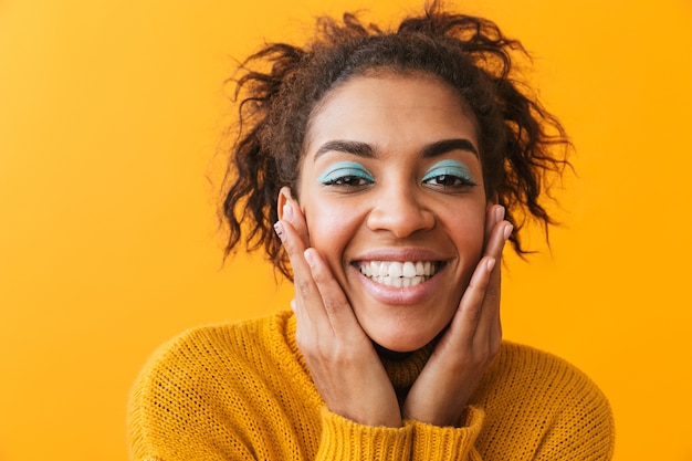 Cheerful young african woman wearing sweater standing isolated