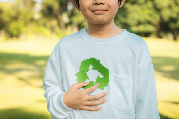 사진 재활용 기호 가이어를 들고 있는 즐거운 젊은 아시아 소년