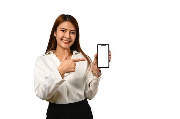 Cheerful young asian woman standing isolated on white background showing mobile phone in hand with empty screen