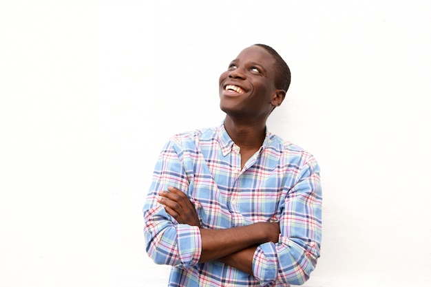 Cheerful young black man with arms crossed and looking up 