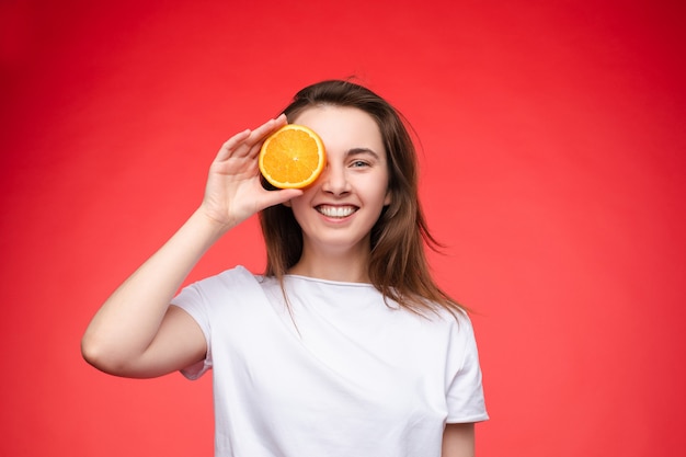 Cheerful young blonde posing with fresh oranges