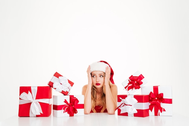 Cheerful young blonde woman with lots of gift boxes