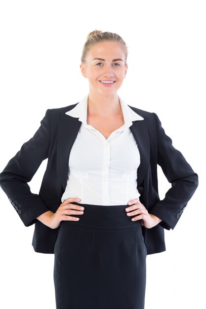 Photo cheerful young businesswoman posing with hands on hips