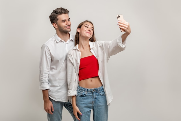사진 쾌활 한 젊은 백인 부부 흰색 배경에 selfie를 복용