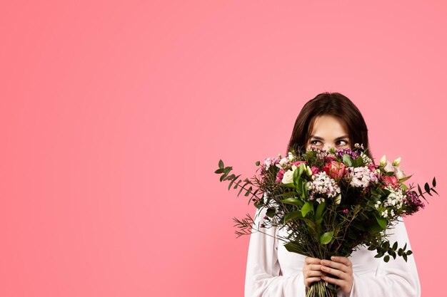 Cheerful young caucasian woman in casual enjoy aroma of bouquet of flowers rejoices gift
