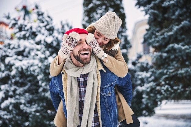 Cheerful young couple dating in winter forest