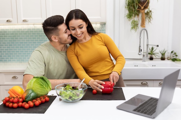 Cheerful young couple looking for nice recipe on Internet