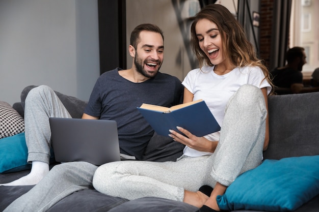 Cheerful young couple relaxing on couch at home