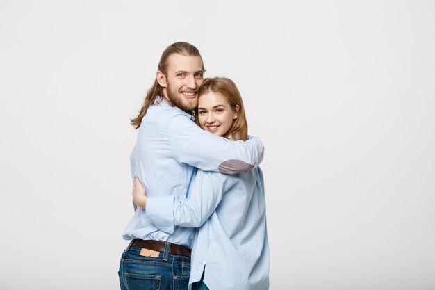 Cheerful young couple standing and hugging each other