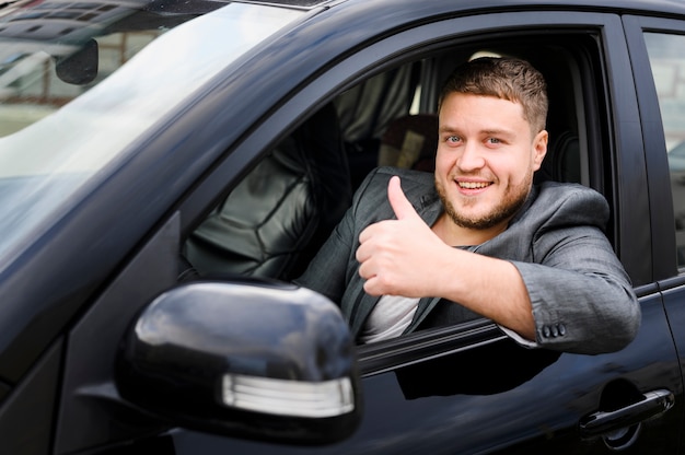 Foto giovane driver allegro che esamina la macchina fotografica