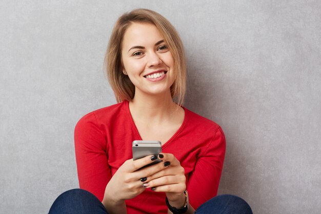 Photo cheerful young female model in red sweater