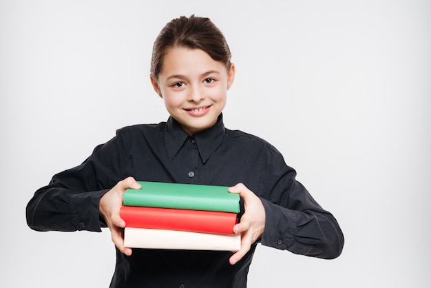 Cheerful young girl holding books