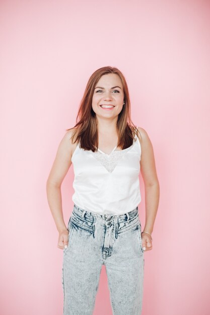 Cheerful young girl in summer clothes gave a lot of fun, picture isolated on pink background