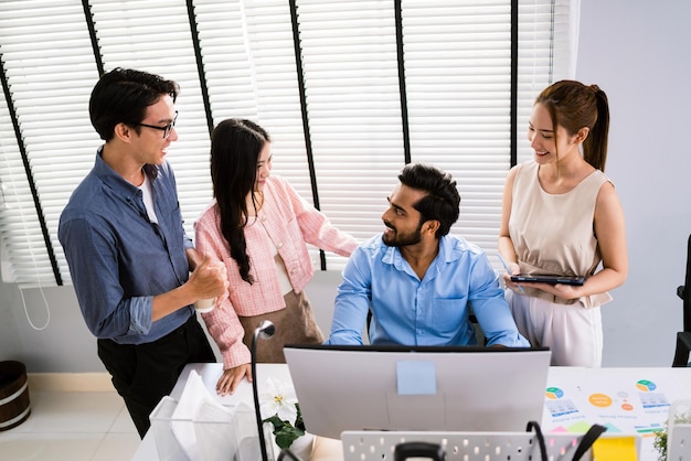 Photo the cheerful young group of asian businessmen in casual with an indian one sitting with colleagues