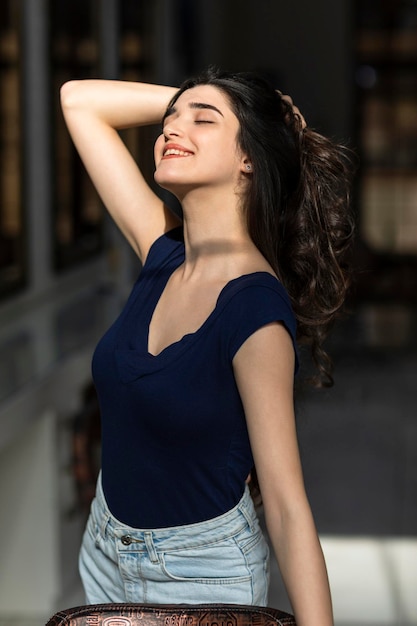 Cheerful young lady put her hand to her hair and smiling High quality photo