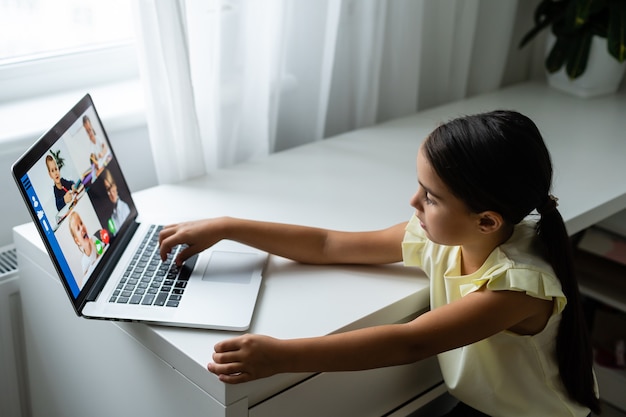 cheerful young little girl children using laptop computer, studying through online e-learning system