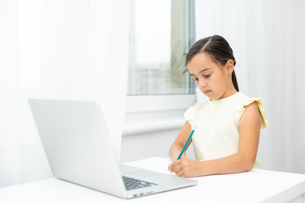 cheerful young little girl children using laptop computer, studying through online e-learning system