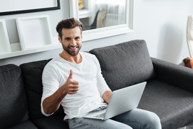 Photo cheerful young man showing thumbs up.