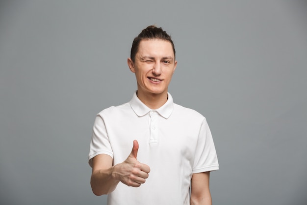 Cheerful young man showing thumbs up.