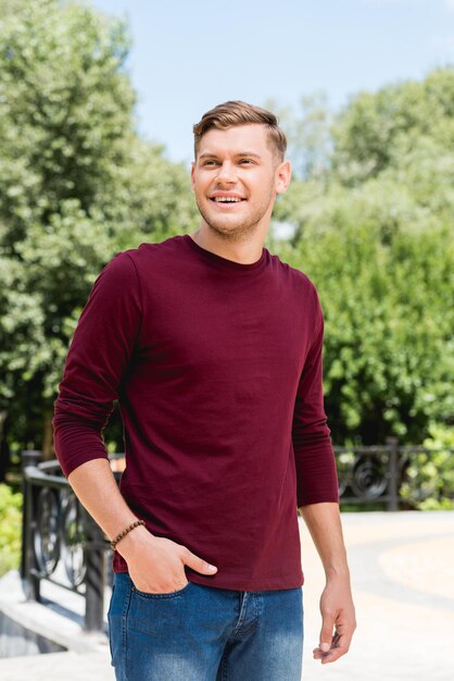 Cheerful young man smiling while standing with hand in pocket