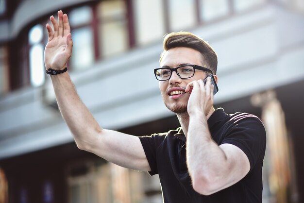 Cheerful young man waving his hand to say hello